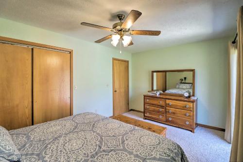 a bedroom with a bed and a ceiling fan at Scenic Riverview Getaway with Screened Porch! in Norfork