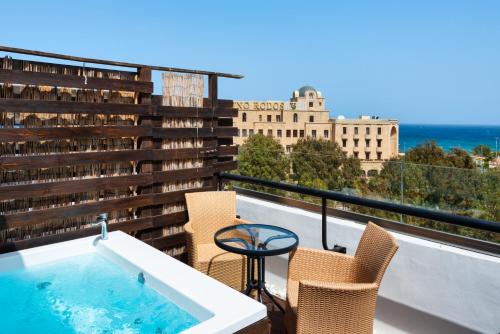 a hot tub on a balcony with chairs and a table at City Center Hotel in Rhodes Town