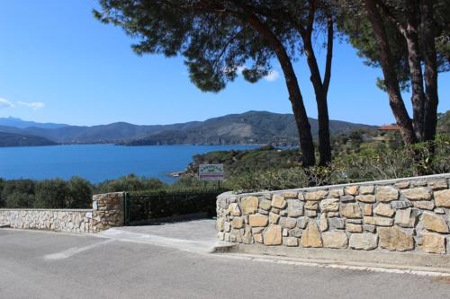 a stone wall next to a body of water at APPARTAMENTI ZUCCALE - A 200 mt dalla spiaggia in Capoliveri