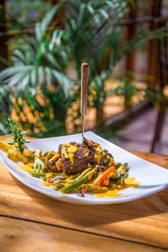a plate of food with meat and vegetables on a table at Hotel de Montaña Suria in San Gerardo de Dota