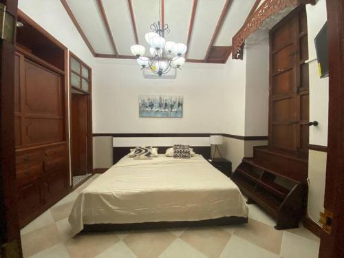 a bedroom with a bed and a chandelier at Apartaestudio amoblado centro histórico de Guadalajara de Buga in Buga