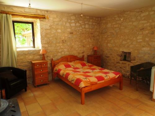 um quarto com uma cama, uma cadeira e uma janela em Les gîtes de Franck em Fayssac