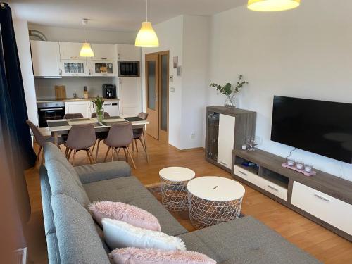 a living room with a couch and a tv and a table at APARTMÁN LUŽNICE TŘEBOŇ in Třeboň