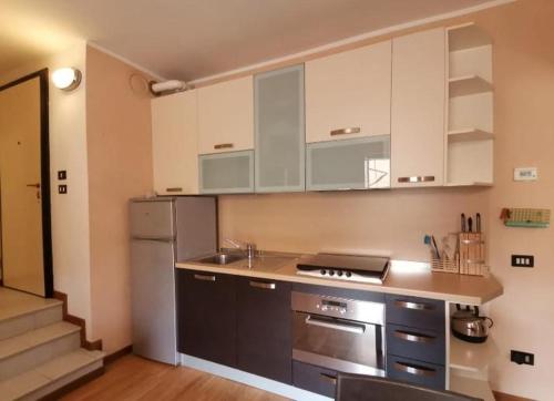 une cuisine avec des armoires blanches et des appareils en acier inoxydable dans l'établissement Casa Clusane d'Iseo 2 passi dal lago, à Clusane