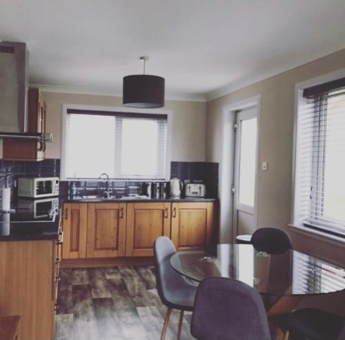 a kitchen with a table and chairs in a kitchen at Wick Holiday Home - NC500 Route in Wick