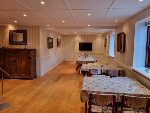 a room with tables and chairs and a flat screen tv at Elling Bed & Breakfast in Frederikshavn
