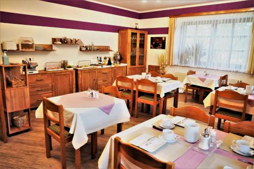 um restaurante com mesas e cadeiras e uma cozinha em Gästehaus Strini em Jennersdorf