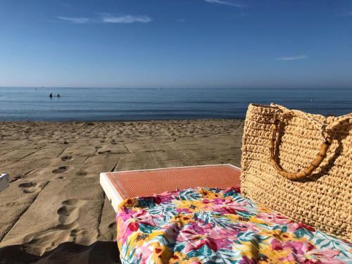 a suitcase sitting on the beach next to the ocean at Casa Acqua Marina in Castiglione della Pescaia