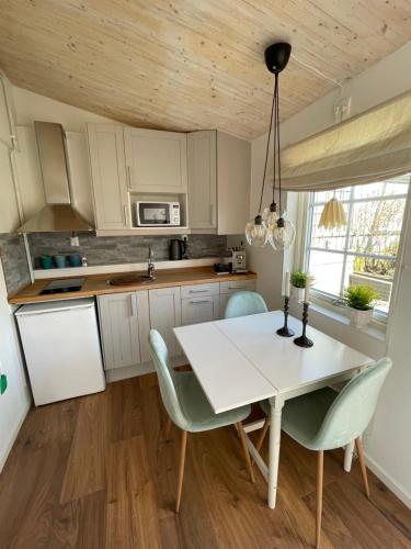a kitchen with a white dining table and chairs at Stuga smögen in Smögen