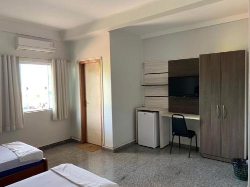 a hotel room with a desk and a tv at HOTEL QUALITY in Parauapebas