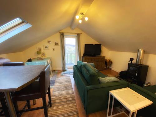 a living room with a green couch and a table at Mandy's Cottage Lanehead - Rural Escape in Bishop Auckland