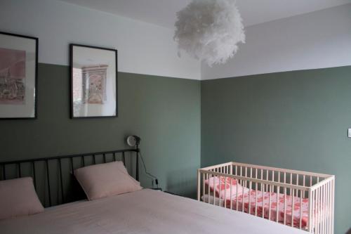 a bedroom with a crib and a ceiling at Aan Wal in Rekem
