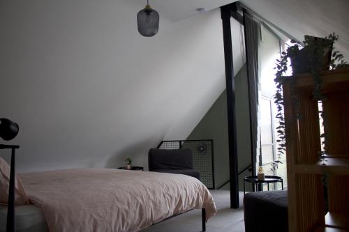 a bedroom with a bed and a chair at Aan Wal in Rekem