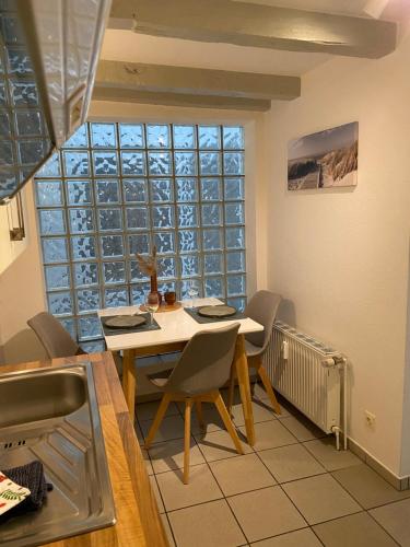 Hafenkoje Husum في هوسوم: غرفة طعام مع طاولة وكراسي ونافذة