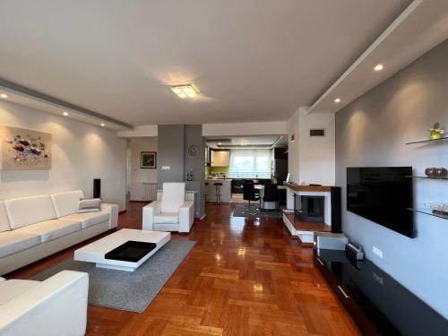 a living room with a white couch and a tv at Apartmani Nova in Karlovac