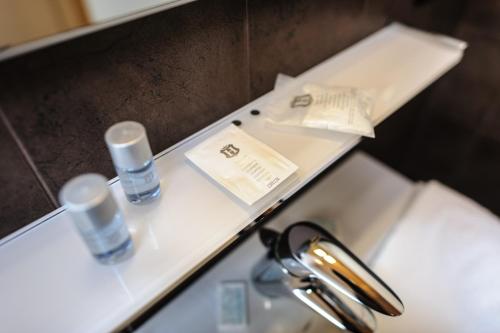 a bathroom sink with two bottles on a counter at Locanda San Paolo in Monza