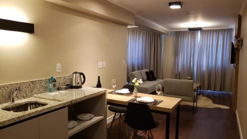 a kitchen and living room with a table and a dining room at Hotel Alvorada in Concordia