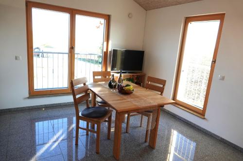 a dining room table with chairs and a television at Weinbergshof Rickel in Kitzingen