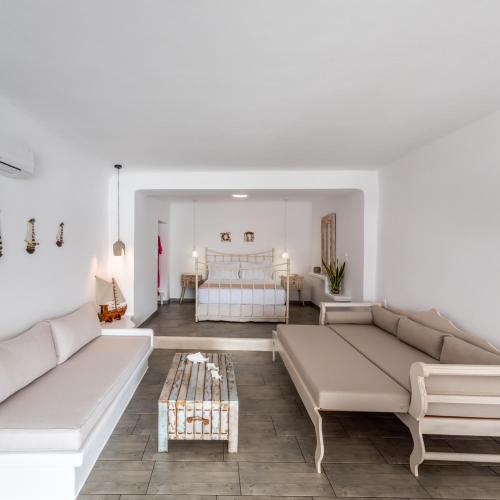 a living room with two couches and a bed at Achinos By The Sea Milos in Agia Irini Milos