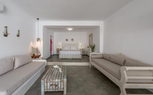 a living room with two couches and a bedroom at Achinos By The Sea Milos in Agia Irini Milos