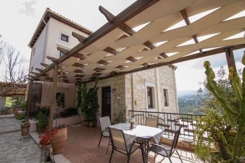 an outdoor patio with a white table and chairs at Kritamos Villa & Apartments in Kamilari