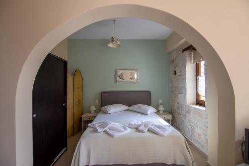 a bedroom with a bed with two towels on it at Kritamos Villa & Apartments in Kamilari