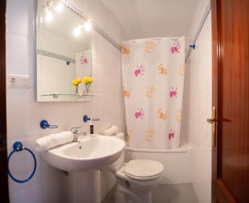 een witte badkamer met een wastafel en een toilet bij Brasil Playa Ha Apartment in Cádiz