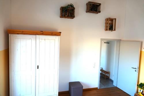 a room with a white closet and a mirror at Weinbergshof Rickel in Kitzingen