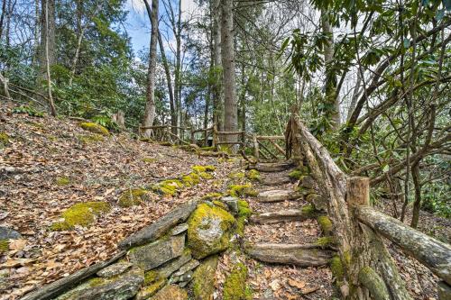 a stone path in the woods with a wooden fence at Beautiful Trillium Home Next to Waterfall! in Cashiers