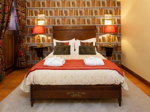 a bedroom with a large bed with book shelves at Charming Antas House in Porto
