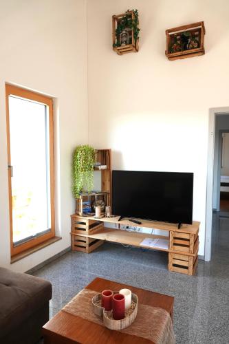 a living room with a large flat screen tv at Weinbergshof Rickel in Kitzingen