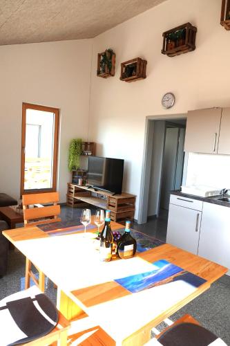 a living room with a table and a kitchen at Weinbergshof Rickel in Kitzingen