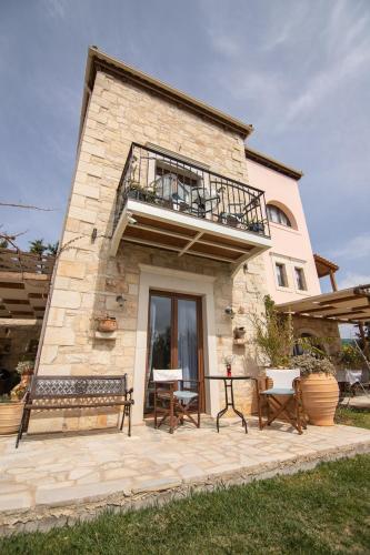 a building with a balcony on top of it at Kritamos Villa & Apartments in Kamilari