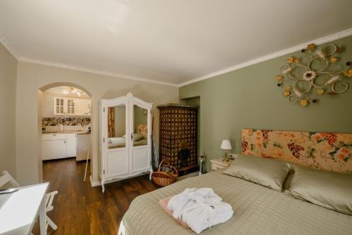 a bedroom with a white bed and a kitchen at GouldVilla Vendégház in Villány