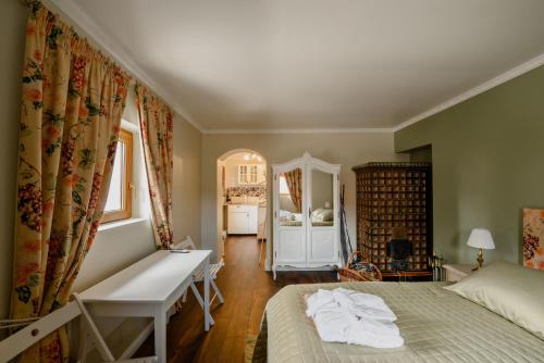 a bedroom with a bed and a desk and a mirror at GouldVilla Vendégház in Villány