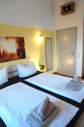 two beds in a room with towels on them at Weinbergshof Rickel in Kitzingen