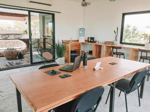 a wooden table with a laptop on top of it at Che Suites Tulum in Tulum