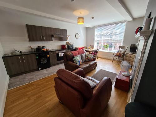 a living room with a couch and a kitchen at Brewsters by Spires Accommodation a comfortable place to stay in the heart of Burton-upon-Trent in Burton upon Trent