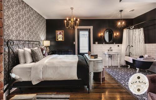 a bedroom with a bed and a bathroom with a sink at Slaymaker & Nichols Gastro House & Inn in Charlottetown
