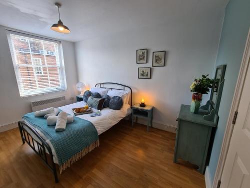 a bedroom with a bed and a couch and a window at Brewsters by Spires Accommodation a comfortable place to stay in the heart of Burton-upon-Trent in Burton upon Trent