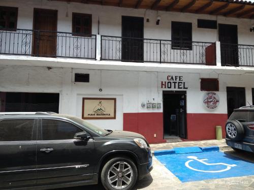 a car parked in front of a large hotel at Hotel Plaza Mazamitla in Mazamitla