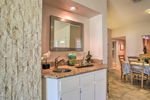 a bathroom with a sink and a mirror and a table at Palm Desert Country Club Home with Pool Access! in Palm Desert