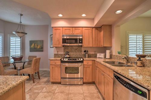 a kitchen with wooden cabinets and stainless steel appliances at Palm Desert Country Club Home with Pool Access! in Palm Desert