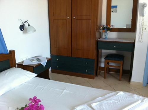 a bedroom with a bed and a cabinet and a desk at Stolidi in Adamas