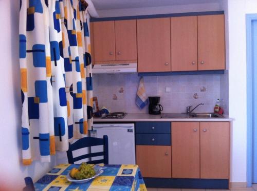 a kitchen with wooden cabinets and a table with a bowl of fruit at Stolidi in Adamas