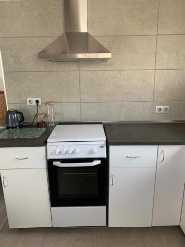 a kitchen with a stove and white cabinets at Ca Liberty in Moraira