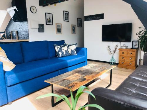 a living room with a blue couch and a wooden table at "LA FABRIQUE" en HYPERCENTRE PARKING GRATUIT in Amiens