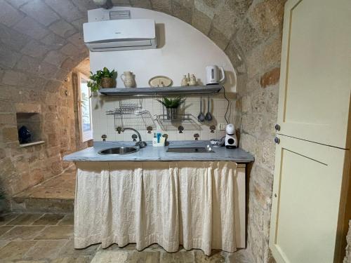 a kitchen with a sink in a stone wall at IL PUMO BLU in Polignano a Mare
