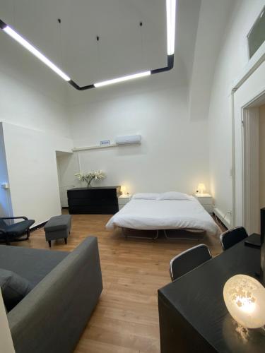 1 dormitorio con cama, sofá y mesa en Palazzo Carmine a due passi dall'Acquario en Génova