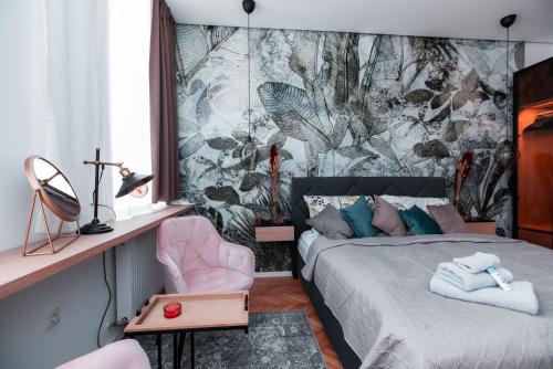 Petit luxe Apartment في فيينا: غرفة نوم بسرير وكرسي